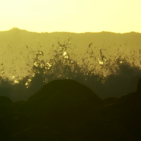 grandes olas a medida que alcanzan la cresta y se rompen en cámara lenta al atardecer 3