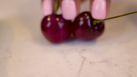 black woman hand is seductively grabbing cherry vegetables on a marble kitchen table