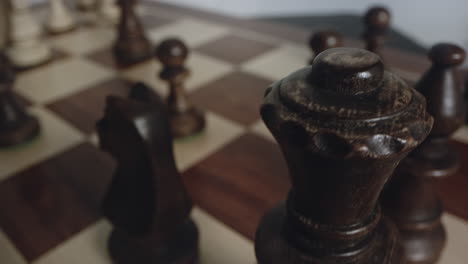 rotating chess board as black king and queen chess pieces come into view, closeup