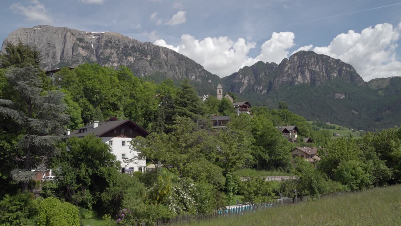 View of part of the village of Voels am Schlern - Fiè allo Sciliar, South Tyrol, Italy on a sunny day in spring. Mountains are in the background.