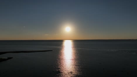 reverse reveal view of sunsetting over mobile bay, alabama