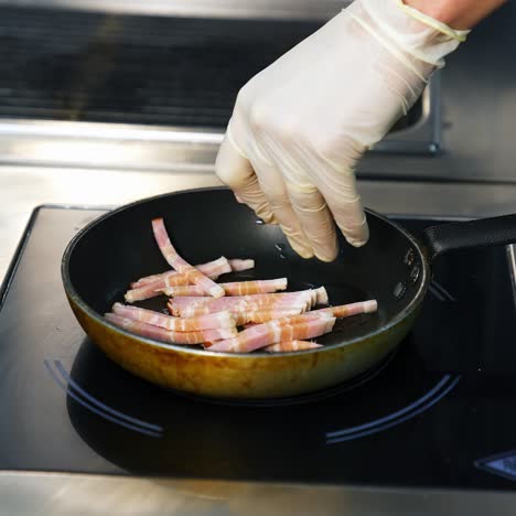 bacon slices in frying pan. man`s hands put bacon on frying pan. unhealthy food