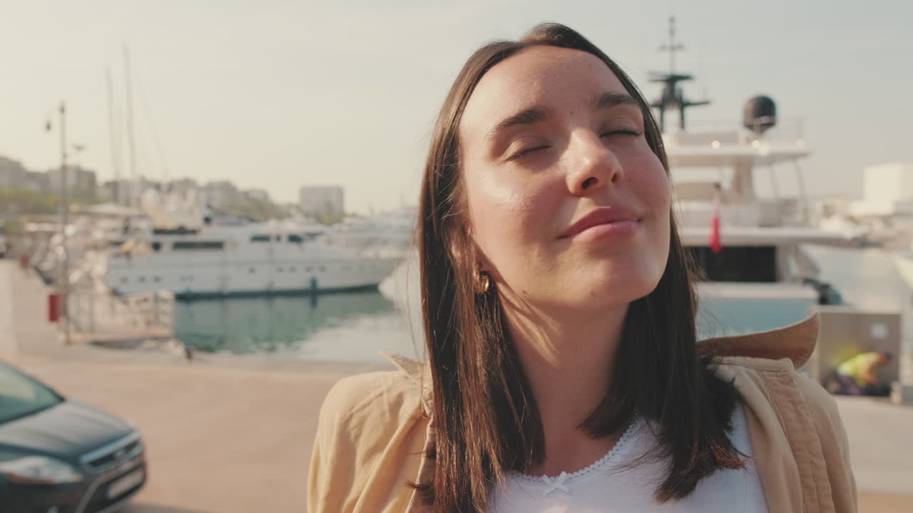 Giovane donna che si gode una giornata di sole in un porto turistico di lusso.