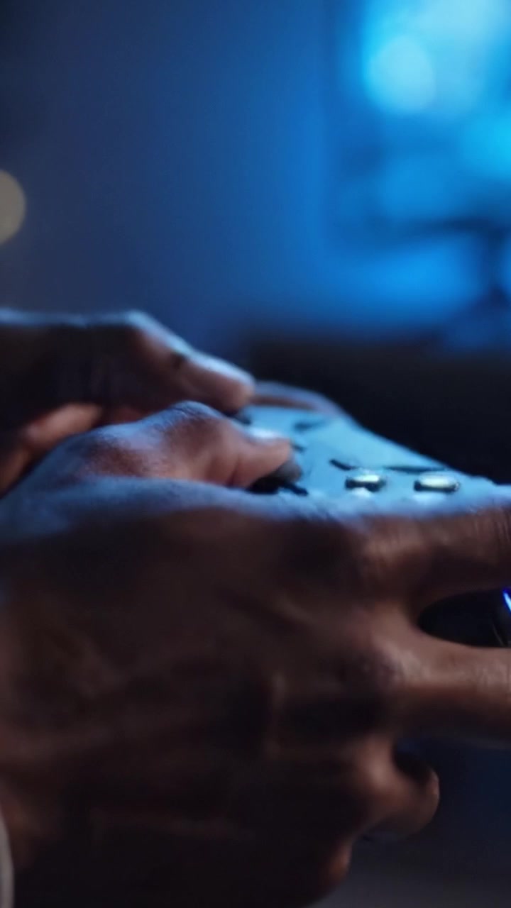 Intense Gaming Session Captured: Close-Up of Hands Gripping a Controller in a Dimly Lit Room, Highlighting the Passion for Video Games and Digital Entertainment.