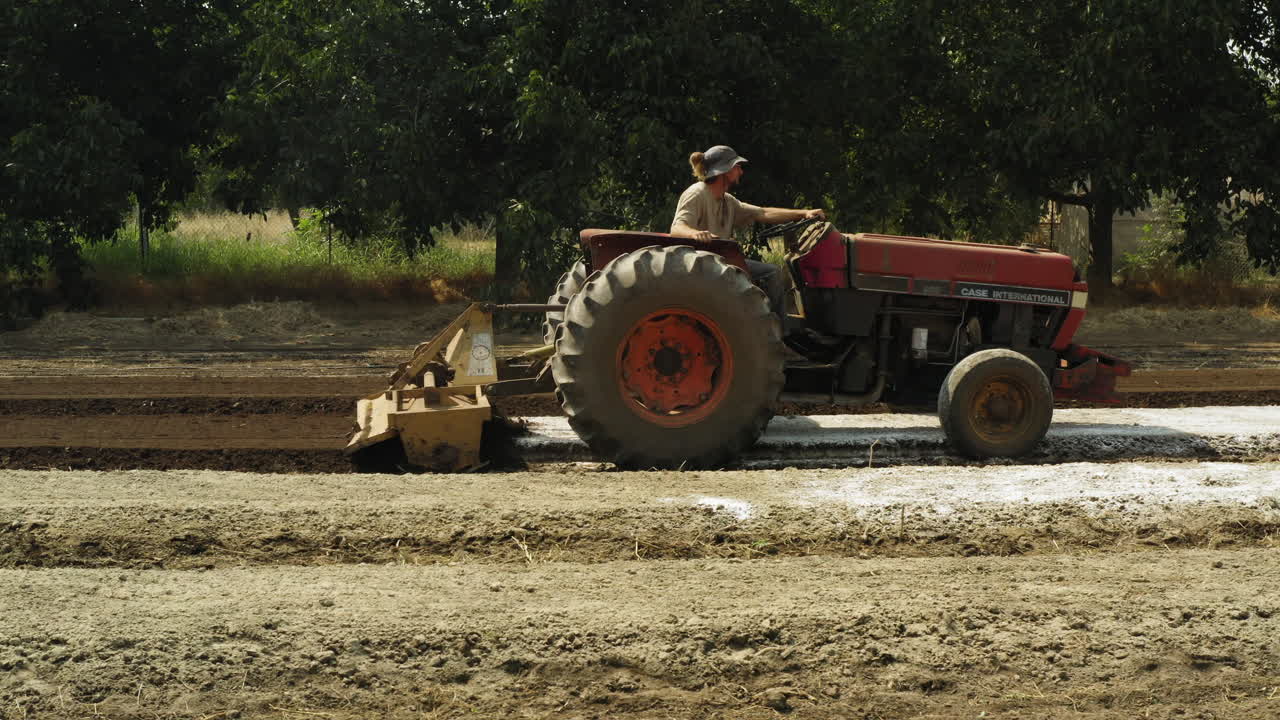 tractor con accesorio especial preparando y labrando el campo, equipo agrícola en cámara lenta