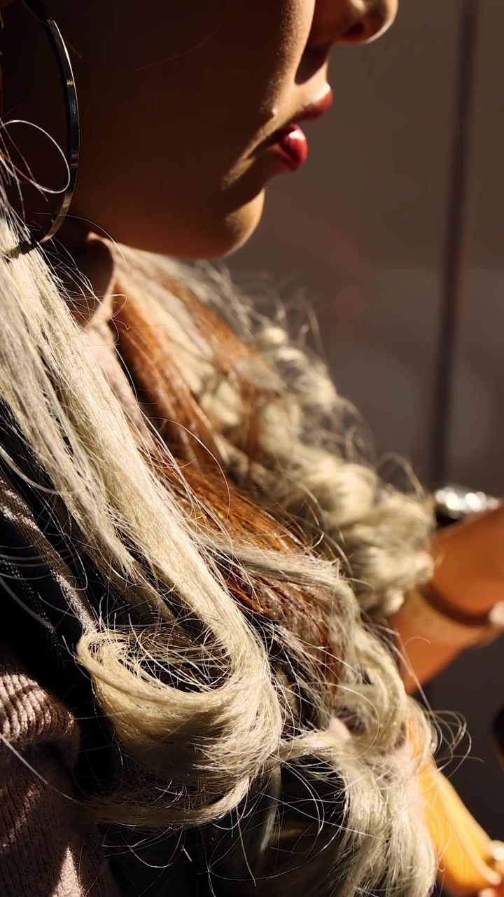 Kvinna med telefon i solljus