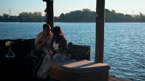 couple covered with blanket having fun by the river