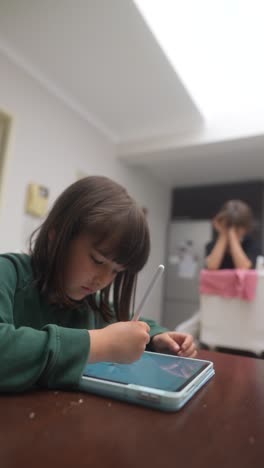 girl drawing on tablet in kitchen