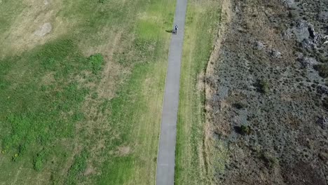 Toma-Aérea,-Seguimiento-De-Una-Persona-En-Bicicleta-En-La-Pista-De-Bicicletas-En-Napier,-Nueva-Zelanda