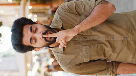 man shushing in outdoor cafe setting