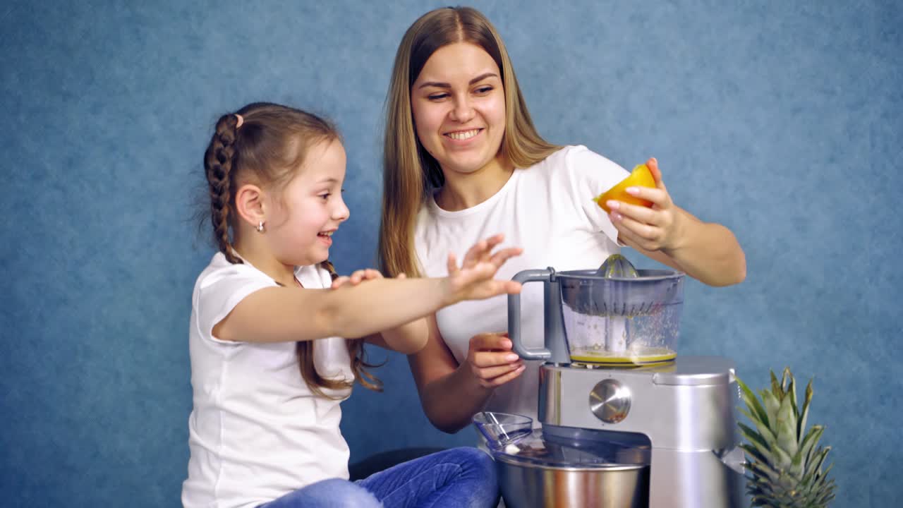 Girl with mother making juice. Portrait view of girls making fresh juice on isolated backgroud