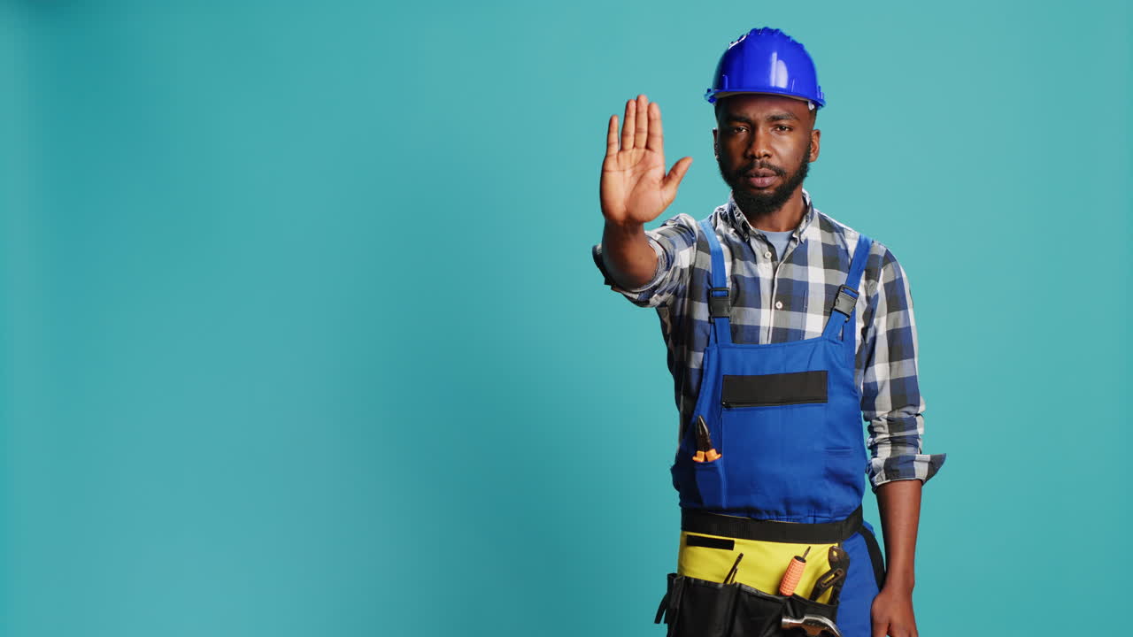 Professional builder raising hand doing stop gesture