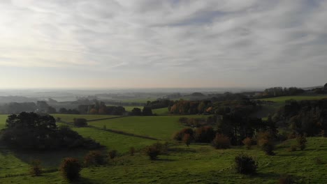 Aerial-view-of-the-soft-green-hills-towards-a-beautiful-sun-in-Odsherred,-Denmark