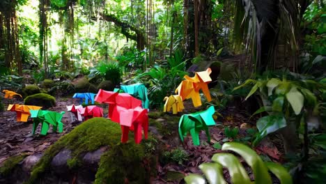 colorful origami animals in a lush forest