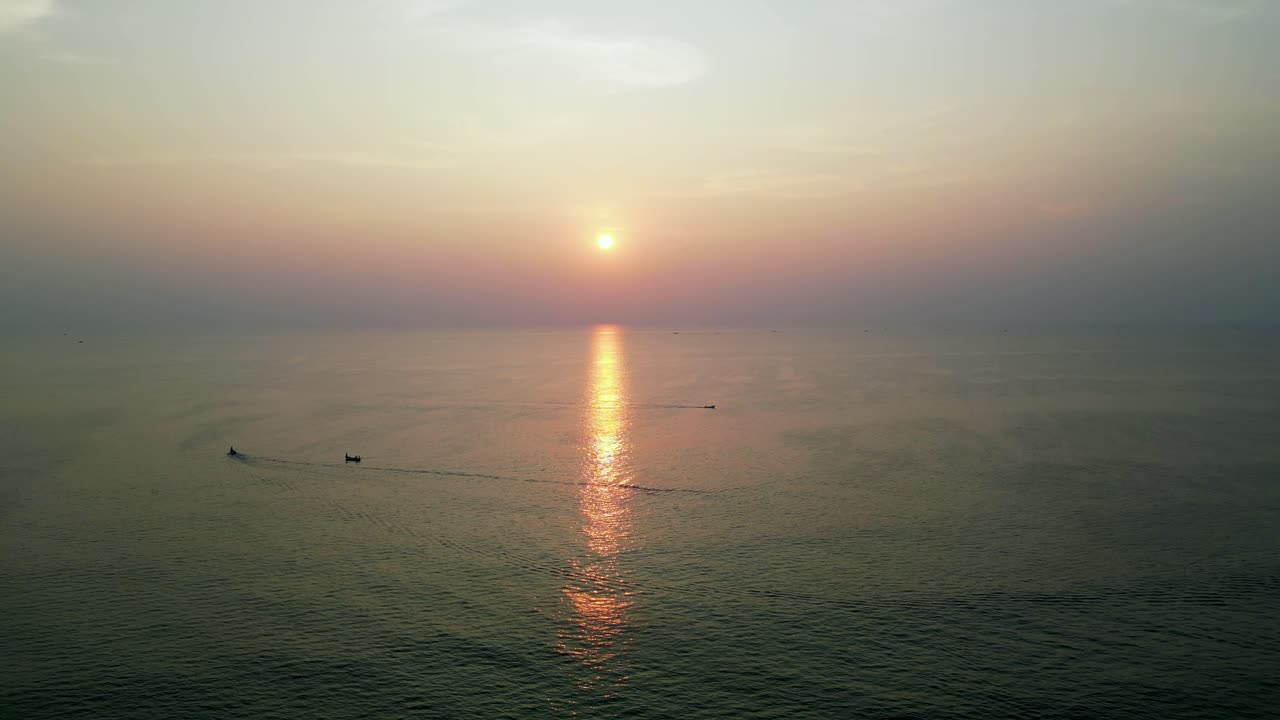 An aerial view of boats sailing on the sparkling sea, with the sun's golden reflections dancing on the water's surface. The vibrant beauty of Goa, India