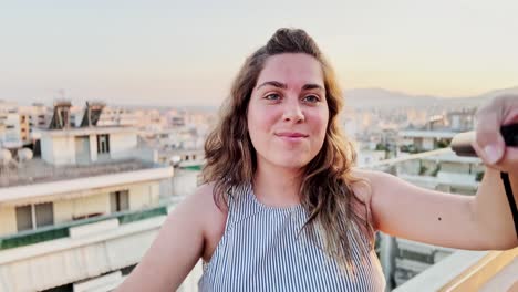 close-up of vlogger woman on athens rooftop at sunset