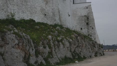 tiro inclinado hacia arriba en las paredes altas de la ciudad blanca del centro antiguo de ostuni, italia