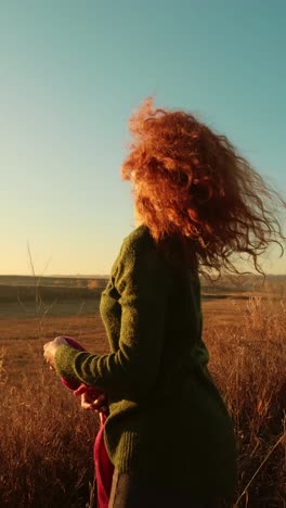 mujer disfrutando de una puesta de sol en un campo