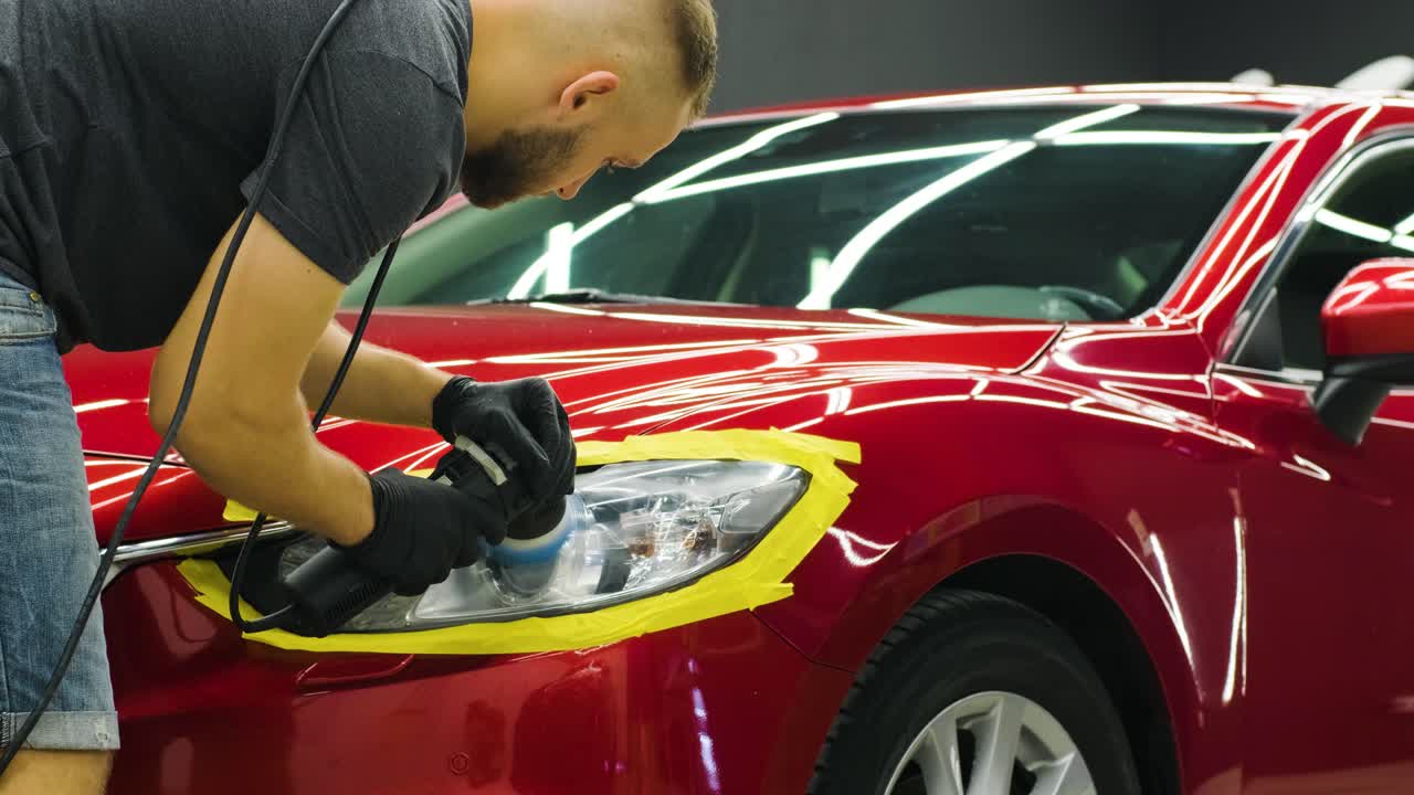 pulido de faros, procesamiento de luces de automóviles. un trabajador de servicio de automóviles pulida el faros de un automóvil de pasajeros. pulido profesional.