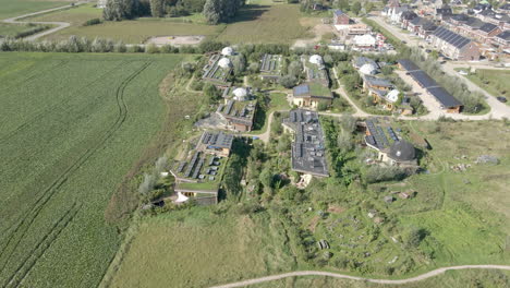 wide aerial of beautiful green earthship village