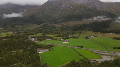 typical landscape in western norway with mountains, forests, fields and mist