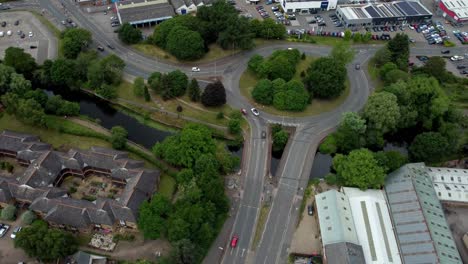 aerial footage rotating around a norwich city roundabout. the frame is slightly panned down and captures various vehicles driving along the road.