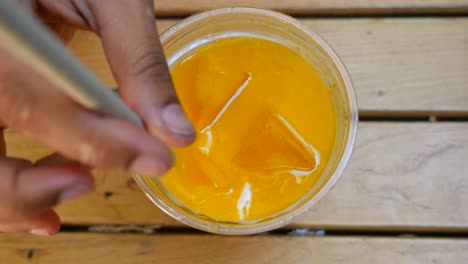orange juice with ice and straw