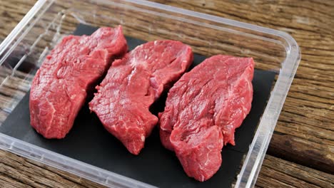 bistec de carne en un recipiente de plástico