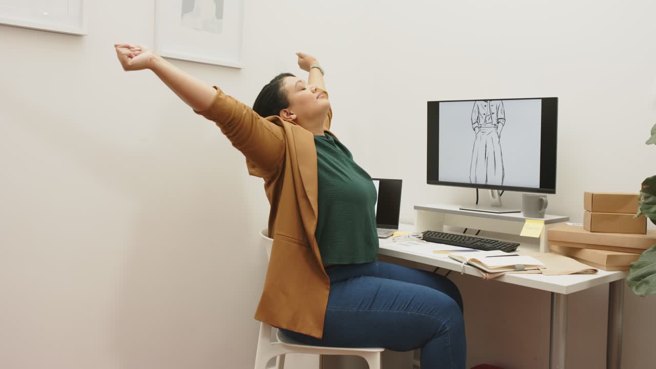 After pausing work, woman is stretching arms overhead, releasing tension, preparing desk return