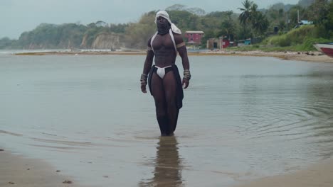 beach scene: a dark-skinned male cosplayer displaying muscles.