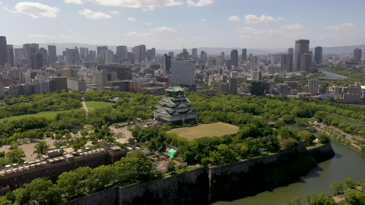 Aerial of Osaka Castle with park, moat, skyscrapers, and city in Osaka, Japan