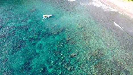 Buceadores-Junto-Al-Barco-Frente-A-La-Costa-En-La-Playa-En-Bali,-Indonesia