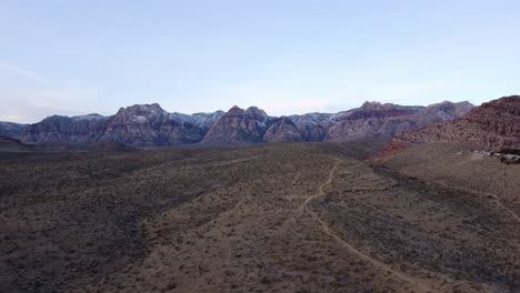 aerial shot of the distant red rock canyon and the desert landscape at sunrise