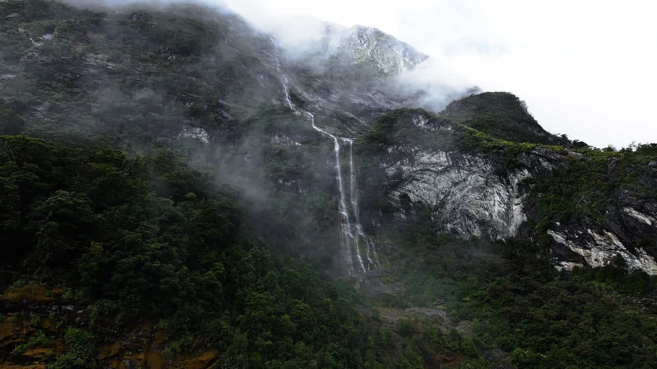 las nubes de niebla flotan majestuosamente frente a las cataratas de tendril en nueva zelanda.