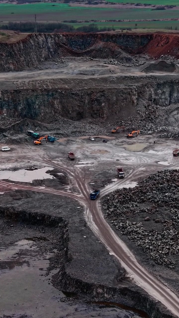 Aerial View of Heavy Trucks Operating in an Open Pit Quarry