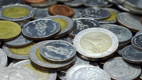 a pile of thai coins, rotating in a studio