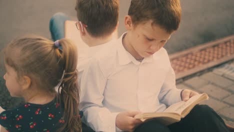 Hermosos-Niños-Se-Preparan-Para-El-Examen-Leyendo-Libros-Vista-Cercana