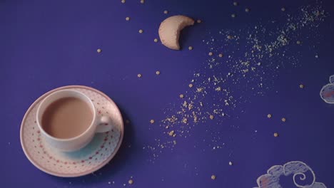 alguien toma de una mesa hecha en forma de un cielo nocturno una taza de café en primer plano