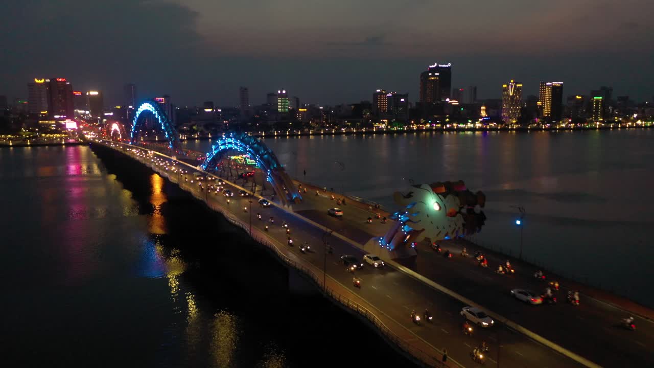 asombrosa foto aérea colorida del puente del dragón cau rong, el tráfico y el horizonte de la ciudad por la noche en danang, vietnam