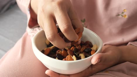 mujer comiendo nueces mixtas