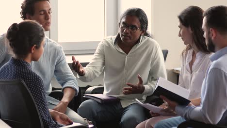 mentor indio consulta a diversos compañeros de trabajo pasantes dan consejos profesionales