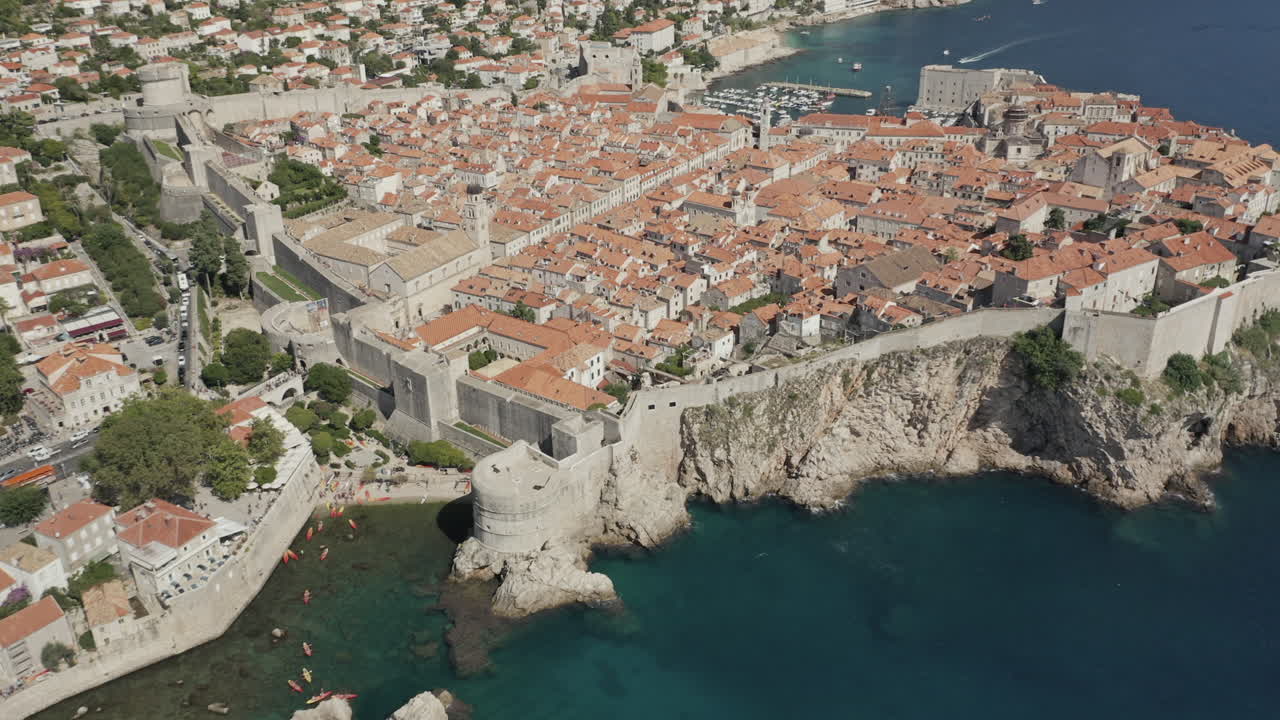 Approaching the old town in Dubrovnik, Croatia by drone with a tilt down on the city walls.
