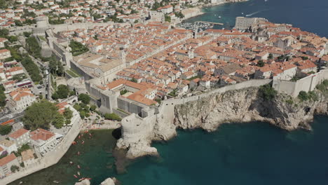 approaching the old town in dubrovnik, croatia by drone with a tilt down on the city walls.