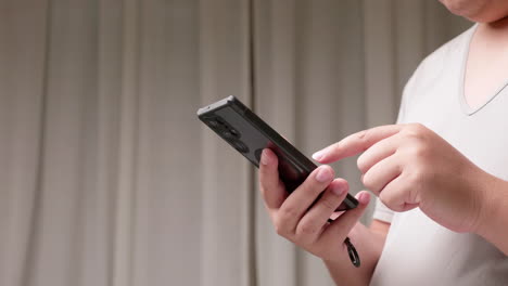 young man texting on smartphone over gray background