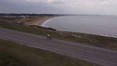vista aérea de un ciclista en órbita en la carretera de punta ballena, uruguay