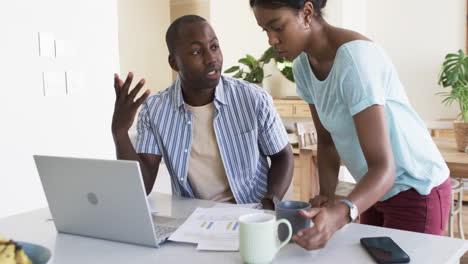 a diverse couple discusses finances at home