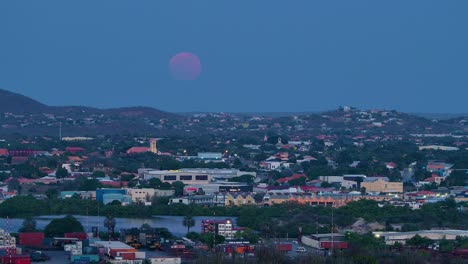 la súper luna azul y roja de sangre se eleva sobre la terminal de contenedores de curacao en willemstad.