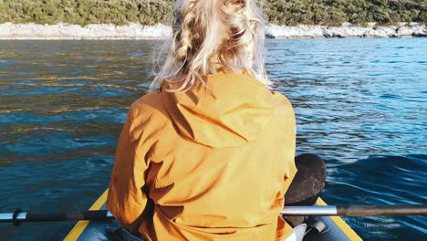 blonde woman relaxing in a kajak in croatia on the ocean