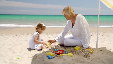 Süßes-Mädchen-Und-Großmutter-Spielen-Am-Strand