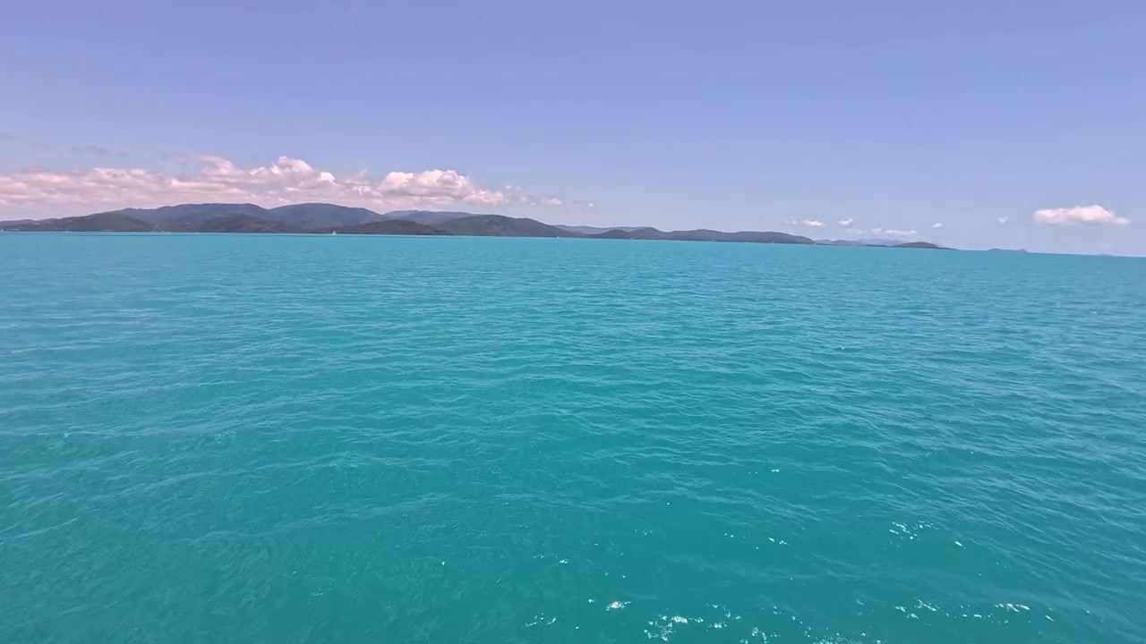 Aguas tranquilas y turquesas del océano e islas tropicales distantes